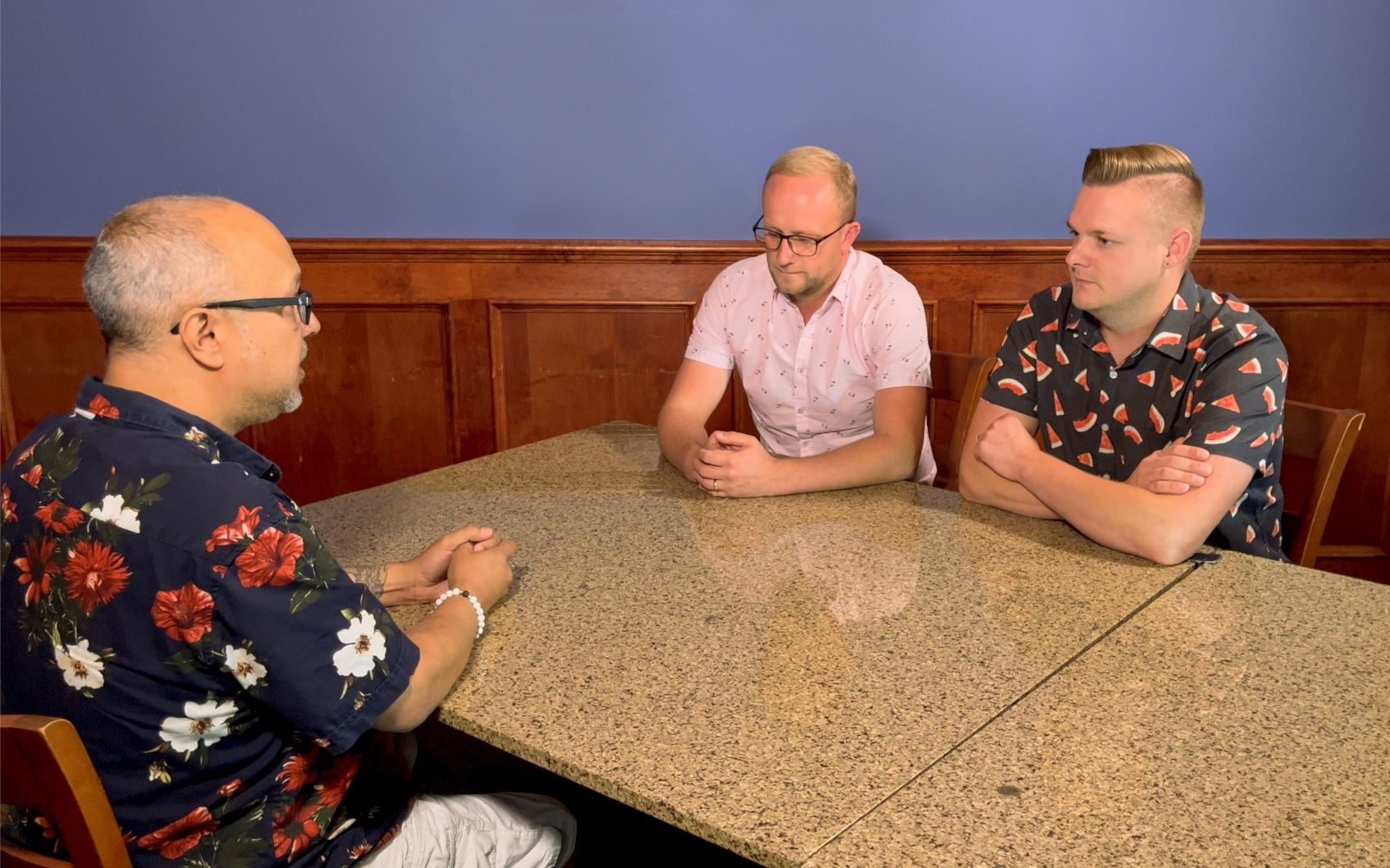 John engaging with two clients at a table